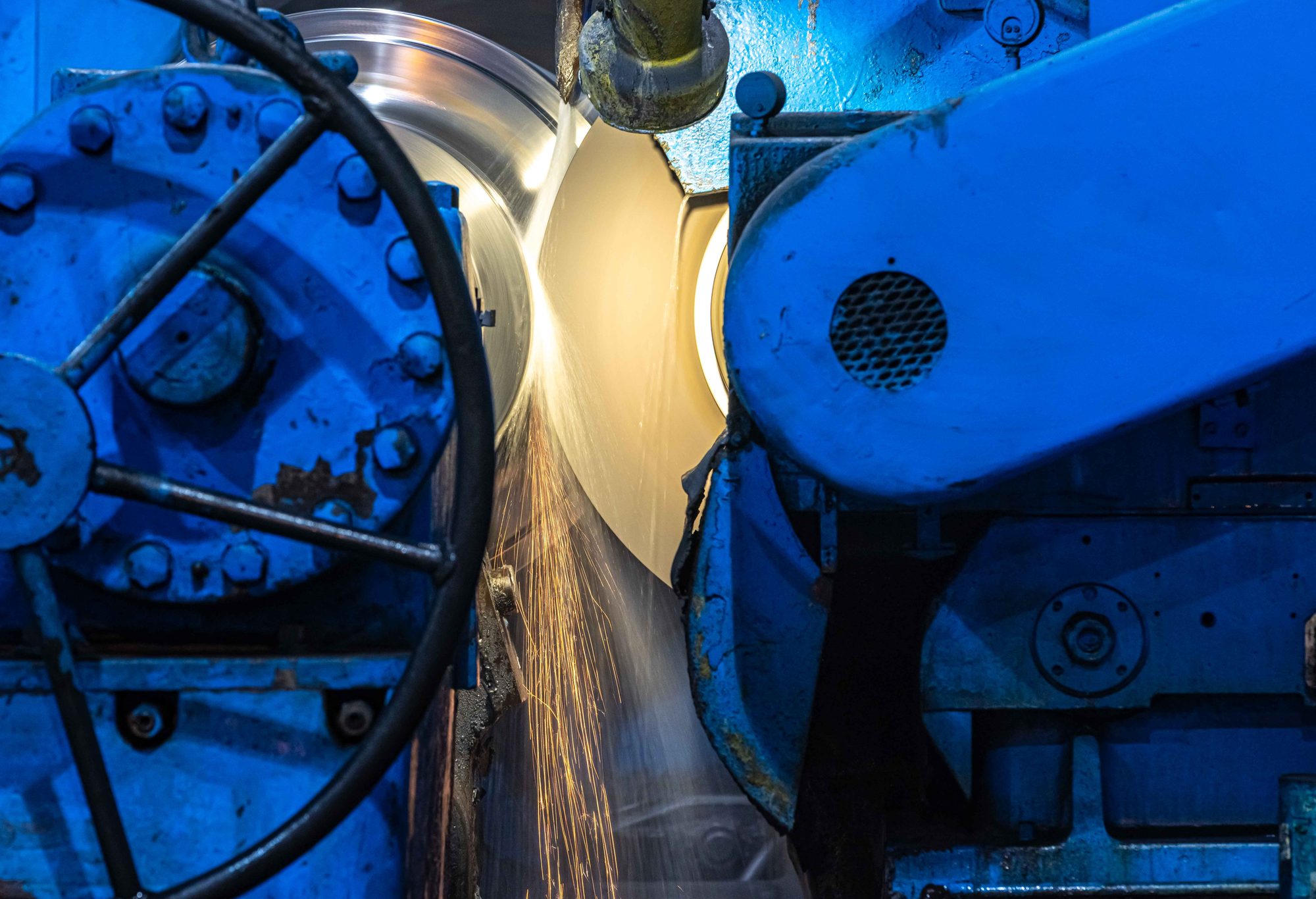 A roll spinning in a grinding machine with a stream of sparks
